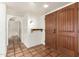 Inviting foyer featuring tiled floors, a decorative shelf, and a solid wood front door at 4527 E Sunrise Dr, Phoenix, AZ 85044