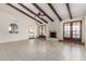 Spacious living room features wood-beam ceiling, fireplace, Saltillo tile, and French doors to outdoor pool at 4527 E Sunrise Dr, Phoenix, AZ 85044