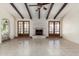 Bright living room with ceiling beams, French doors, and a brick fireplace at 4527 E Sunrise Dr, Phoenix, AZ 85044