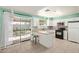 White kitchen with stone countertops, stainless microwave, and view of the backyard at 4624 S Fair Ln, Tempe, AZ 85282