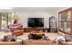 Bright living room featuring wood-look floors, a large TV, and rustic wood accents for a warm, inviting feel at 4812 E Winston Dr # 2, Phoenix, AZ 85044