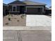 Exterior shot of a single-story house with stone accents and a two-car garage at 5741 E Iris Dr, Florence, AZ 85132