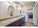 Bathroom with double sink vanity with granite counters and dark cabinets and a walk-in closet at 6145 E Cave Creek Rd # 203, Cave Creek, AZ 85331