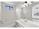 Bright bathroom with a white vanity, tub, and shower, showcasing modern fixtures and ample space at 6410 W Winslow Ave, Phoenix, AZ 85043
