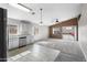Open-concept kitchen with white cabinets, stainless steel appliances, and adjacent living area at 6410 W Winslow Ave, Phoenix, AZ 85043
