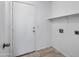 Bright mud room with a tile floor, white door, shelf and visible utility connections for appliances at 6410 W Winslow Ave, Phoenix, AZ 85043