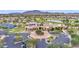 Aerial view of the community clubhouse, pool, tennis courts, parking, and desert landscape at 6811 S Four Peaks Way, Chandler, AZ 85249
