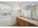 Bathroom featuring wood cabinets, granite countertops, double sinks, walk-in closet and shower at 6811 S Four Peaks Way, Chandler, AZ 85249