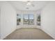 This carpeted bedroom has a ceiling fan and a large bay window with views of the neighborhood at 6811 S Four Peaks Way, Chandler, AZ 85249