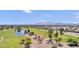 Scenic aerial view of community featuring lush green golf courses, a serene lake, and the picturesque backdrop of mountain views at 6811 S Four Peaks Way, Chandler, AZ 85249
