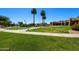 Expansive green space with walking paths, palm trees, and desert landscaping offers a tranquil outdoor experience for residents at 6811 S Four Peaks Way, Chandler, AZ 85249