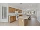 Traditional kitchen features wood cabinets, granite counters, white appliances, and a center island, flowing into an open-concept living space at 6811 S Four Peaks Way, Chandler, AZ 85249