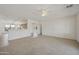 Open living room showcases neutral carpet, tile flooring, ceiling fan, and an entrance to the kitchen at 6811 S Four Peaks Way, Chandler, AZ 85249