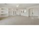 Open concept living room shows built-in shelving, neutral carpet, and tile flooring near entry at 6811 S Four Peaks Way, Chandler, AZ 85249