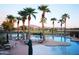 Resort-style pool area featuring multiple pools, palm trees, lounge chairs, and mountain views at 6811 S Four Peaks Way, Chandler, AZ 85249
