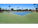 Bright blue and green tennis court set in a community with well-maintained landscaping and covered seating areas at 6811 S Four Peaks Way, Chandler, AZ 85249