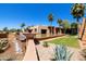 Unique water feature with a waterfall, lush landscaping, palm trees, and a desert building backdrop at 6811 S Four Peaks Way, Chandler, AZ 85249
