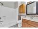 Bathroom with tub shower, wood cabinet sink, tiled backsplash and ample storage at 6837 S Roosevelt St, Tempe, AZ 85283