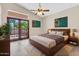 Bedroom with modern decor, king bed, ceiling fan, and access to the backyard through french doors at 6837 S Roosevelt St, Tempe, AZ 85283