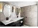 Modern bathroom featuring a double vanity with sleek black hardware and elegant gray tile walls and flooring at 7508 N 13Th Ave, Phoenix, AZ 85021