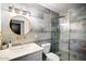 Stylish bathroom with elegant blue-gray tiles, gold fixtures, and a glass-enclosed shower, creating a spa-like ambiance at 7508 N 13Th Ave, Phoenix, AZ 85021