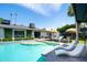 Backyard featuring a sparkling pool, lounge chairs, green lawn, and the home's exterior at 7508 N 13Th Ave, Phoenix, AZ 85021