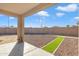 A relaxing covered patio overlooks the backyard with gravel, artificial turf, and block wall at 7580 W Darrel Rd, Laveen, AZ 85339