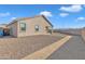 A view of the rear of the house and gravel-filled backyard with a path of artificial turf at 7580 W Darrel Rd, Laveen, AZ 85339