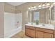 Bathroom showcases a double vanity with wood cabinets and tub with shower, offering functionality and style at 7580 W Darrel Rd, Laveen, AZ 85339
