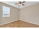 Well-lit bedroom with wood flooring, ceiling fan, and a large window, offering comfort and scenic views at 7580 W Darrel Rd, Laveen, AZ 85339