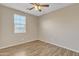 Bright bedroom showcases hardwood flooring, a ceiling fan, and a window with blinds, providing comfort at 7580 W Darrel Rd, Laveen, AZ 85339
