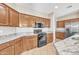 This kitchen features wood cabinetry, granite countertops, and stainless steel appliances at 7580 W Darrel Rd, Laveen, AZ 85339