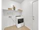 Laundry room features a modern washing machine, decor shelves, and white walls, providing a clean and functional space at 7580 W Darrel Rd, Laveen, AZ 85339