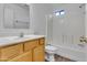 Bright bathroom with a wooden vanity, white countertop, and a shower with white tile at 827 E Pecan Rd, Phoenix, AZ 85040