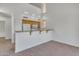 Open kitchen with wood cabinets, white appliances, and carpeted living space at 827 E Pecan Rd, Phoenix, AZ 85040
