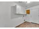 Laundry room with wooden floors, white cabinets, and washer/dryer hookups at 827 E Pecan Rd, Phoenix, AZ 85040