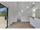 Open-plan living space with high ceilings, white walls, neutral carpet, and sliding glass door at 827 E Pecan Rd, Phoenix, AZ 85040