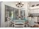 Bright dining area with a round table, white chairs, a stylish chandelier, and views of the pool at 9004 S Ash Ave, Tempe, AZ 85284