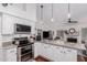 Modern kitchen featuring granite countertops, white cabinets, stainless steel appliances, and adjacent living area with fireplace at 9004 S Ash Ave, Tempe, AZ 85284