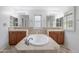Elegant bathroom with a central tub, double sinks, stylish vanities, and decorative lighting at 970 S Henry Ln, Gilbert, AZ 85296