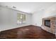 Spacious living room with a stone fireplace, hardwood floors, and large window at 970 S Henry Ln, Gilbert, AZ 85296