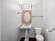 Small powder room with a pedestal sink, decorative mirror, and modern fixtures at 970 S Henry Ln, Gilbert, AZ 85296