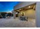 Covered back patio with ceiling fan, outdoor dining table, and fire pit at 9845 E Edgestone Dr, Scottsdale, AZ 85255