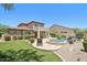 An expansive backyard with a pool, spa, covered patio, and well-manicured landscaping at 9845 E Edgestone Dr, Scottsdale, AZ 85255
