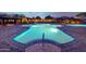 Illuminated community pool at night with cozy seating areas, perfect for relaxing and socializing at 9845 E Edgestone Dr, Scottsdale, AZ 85255