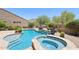 Beautiful backyard pool and spa with stone accents, a waterfall feature, and desert landscaping at 9845 E Edgestone Dr, Scottsdale, AZ 85255