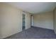 This bedroom has neutral walls, carpet, and open doorways to the closet and hall at 10410 N Cave Creek Rd # 2220, Phoenix, AZ 85020