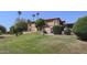 Inviting condo with lush green lawn and mature palm trees set against a clear blue sky at 10410 N Cave Creek Rd # 2220, Phoenix, AZ 85020