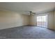 Bright living room featuring neutral walls, carpeting, a ceiling fan, and a sliding glass door to the outside at 10410 N Cave Creek Rd # 2220, Phoenix, AZ 85020