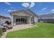 A covered patio with travertine flooring, opening onto a backyard oasis with green grass at 10509 W Harmony Ln, Peoria, AZ 85382